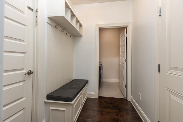 mudroom with dark wood-style flooring and baseboards
