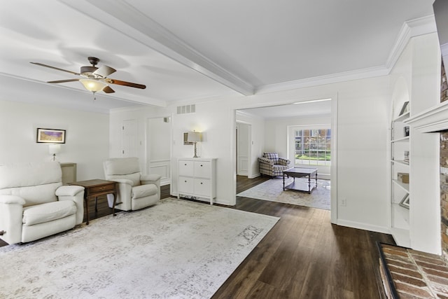 living area with ceiling fan, dark wood-type flooring, ornamental molding, beamed ceiling, and baseboards