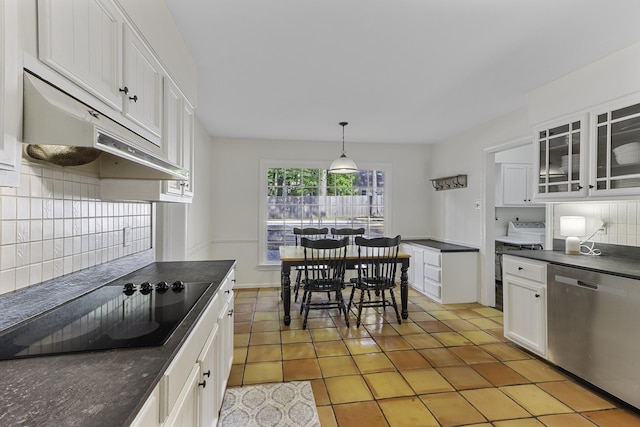 kitchen featuring stainless steel dishwasher, dark countertops, under cabinet range hood, backsplash, and black electric stovetop
