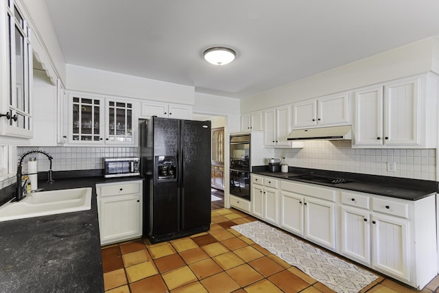 kitchen featuring black appliances, under cabinet range hood, a sink, and tasteful backsplash