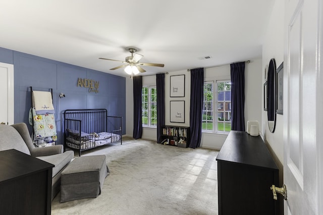 bedroom with light carpet and a ceiling fan