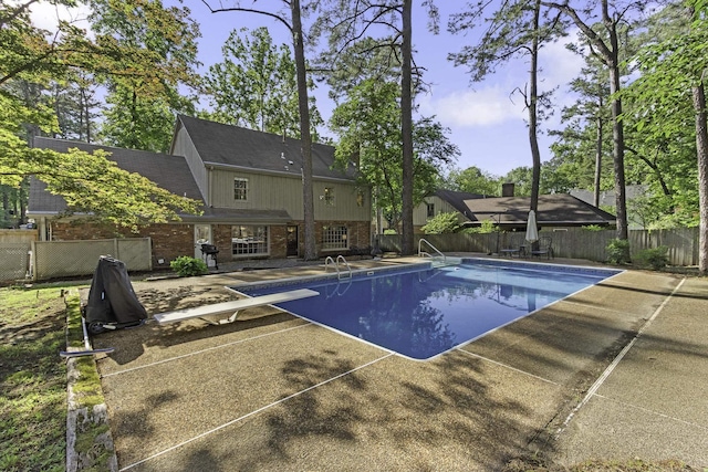 view of swimming pool with a patio, a diving board, and area for grilling