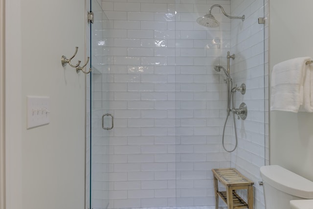 bathroom with a shower stall and toilet