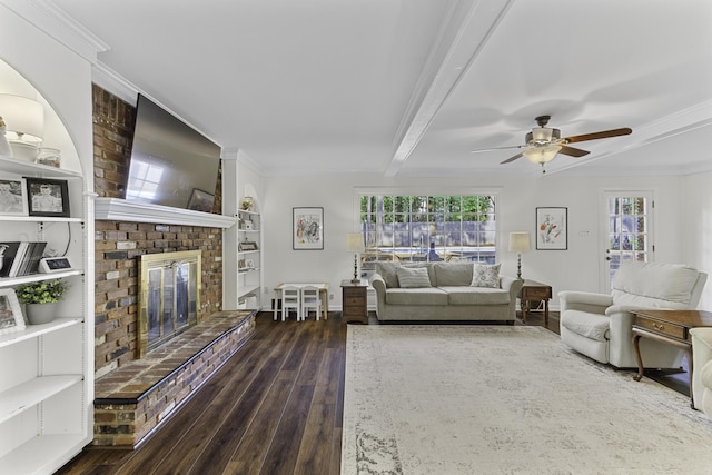 living area featuring wood-type flooring, a fireplace, ceiling fan, beamed ceiling, and built in features
