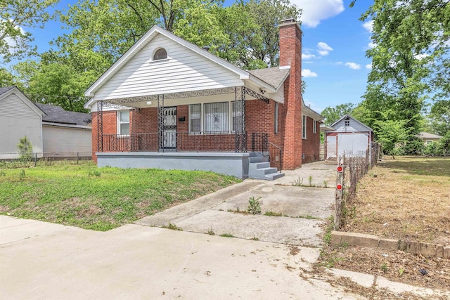 686 Looney Ave, Memphis, TN 38107 - bungalow with brick siding, covered porch, a chimney, and fence