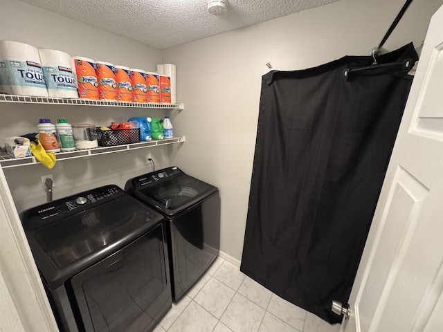 laundry area featuring washing machine and clothes dryer and a textured ceiling