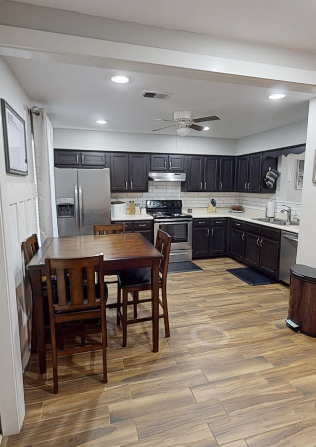 kitchen with stainless steel appliances, light wood finished floors, tasteful backsplash, light countertops, and recessed lighting