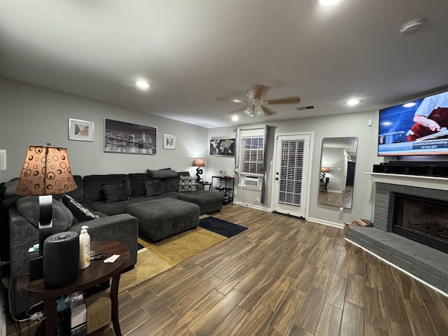 living area featuring ceiling fan, wood finished floors, recessed lighting, a brick fireplace, and baseboards