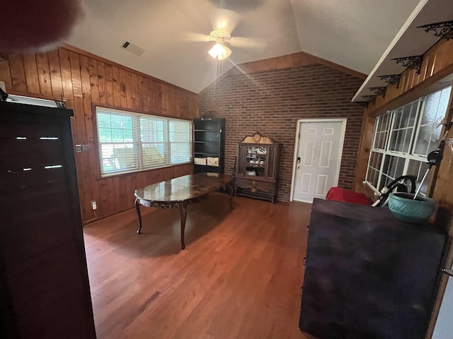 8130 Julie Cv, Millington, TN 38053 - living room featuring brick wall, lofted ceiling, a ceiling fan, wood finished floors, and wooden walls