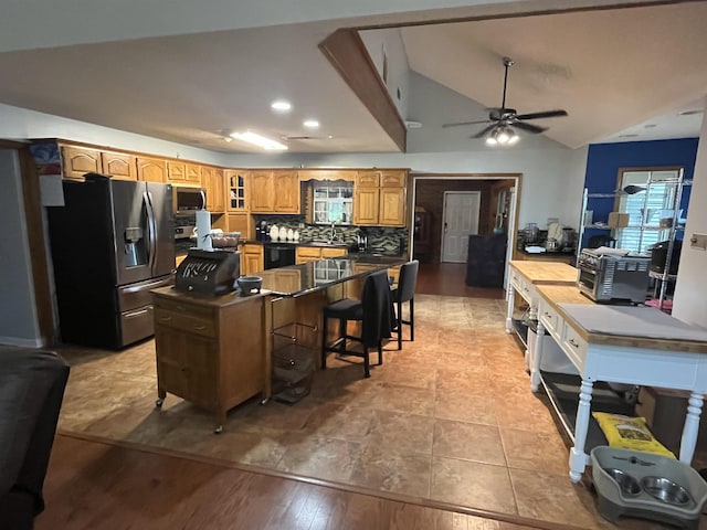 8130 Julie Cv, Millington, TN 38053 - kitchen with appliances with stainless steel finishes, dark countertops, a ceiling fan, a breakfast bar, and glass insert cabinets
