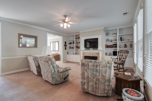 living room with a fireplace, a ceiling fan, crown molding, light colored carpet, and baseboards