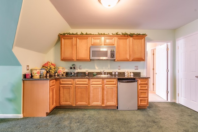 kitchen featuring stainless steel microwave, carpet, a sink, dark stone countertops, and dishwasher