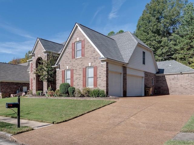 traditional-style house with brick siding, roof with shingles, a front lawn, and driveway