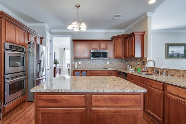 kitchen with appliances with stainless steel finishes, a sink, a chandelier, a center island, and light wood-style flooring