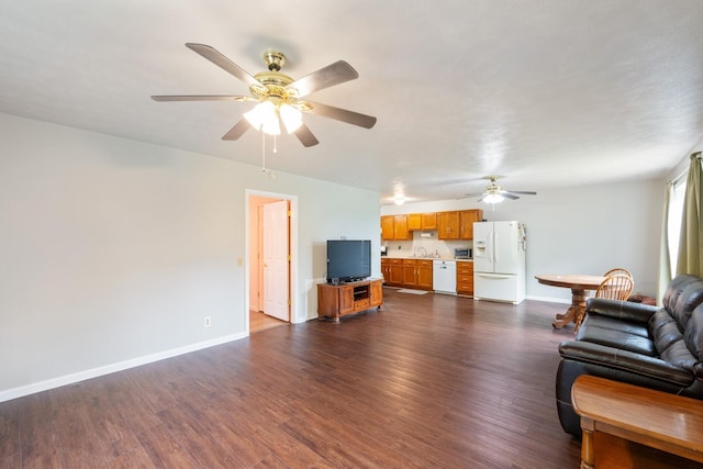 living area with ceiling fan, baseboards, and dark wood-style flooring