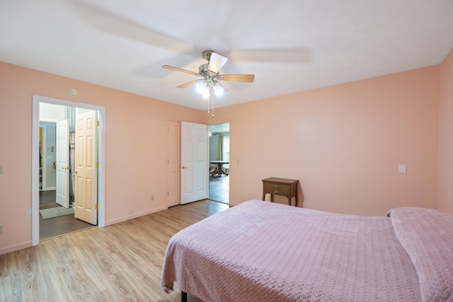 bedroom with light wood finished floors, baseboards, ceiling fan, and connected bathroom