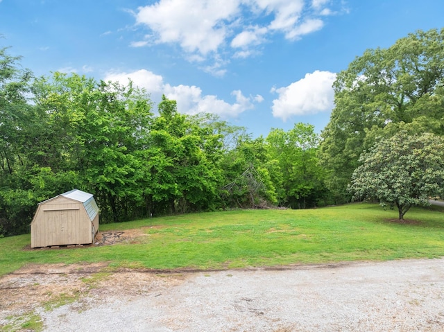 view of green lawn featuring a storage unit and an outbuilding