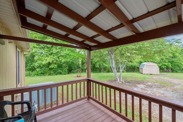 deck with a storage shed, an outbuilding, and a yard