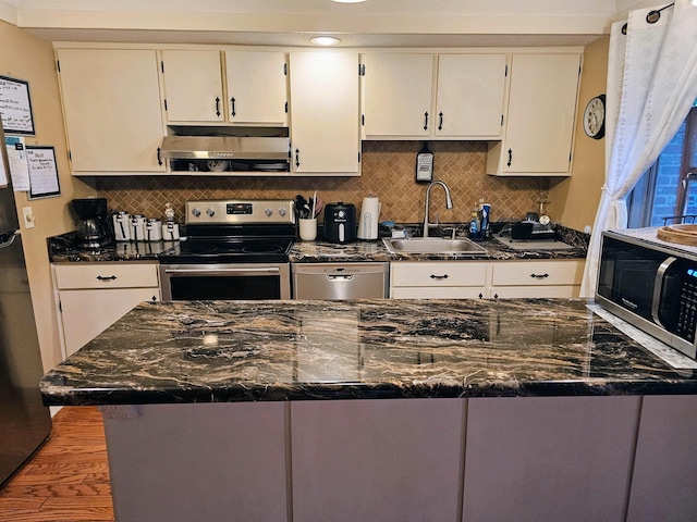 1212 Bristol Dr Unit 1212, Memphis, TN 38119 - kitchen with appliances with stainless steel finishes, extractor fan, a sink, backsplash, and white cabinets
