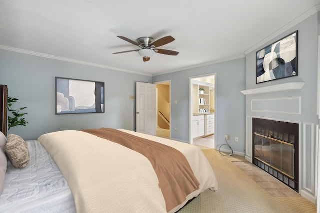 bedroom with a fireplace with flush hearth, light carpet, crown molding, ensuite bathroom, and a ceiling fan
