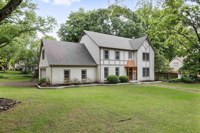 tudor-style house featuring brick siding, roof with shingles, and an attached garage