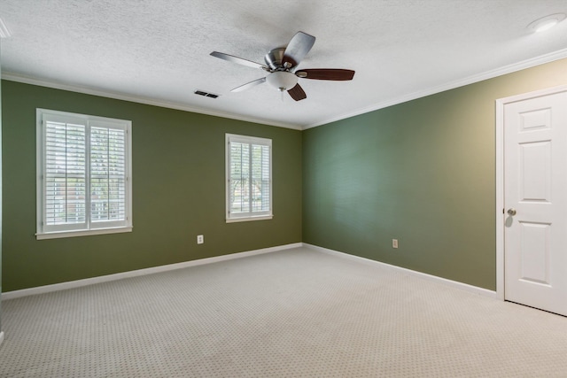 unfurnished room with healthy amount of natural light, ornamental molding, ceiling fan, light colored carpet, and baseboards