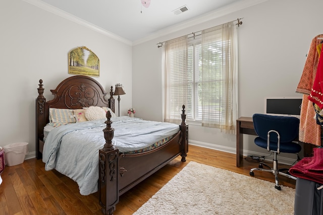 bedroom featuring ornamental molding, wood finished floors, an office area, and baseboards