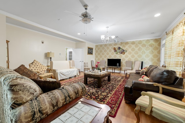 living room with wallpapered walls, wood finished floors, an accent wall, crown molding, and a chandelier
