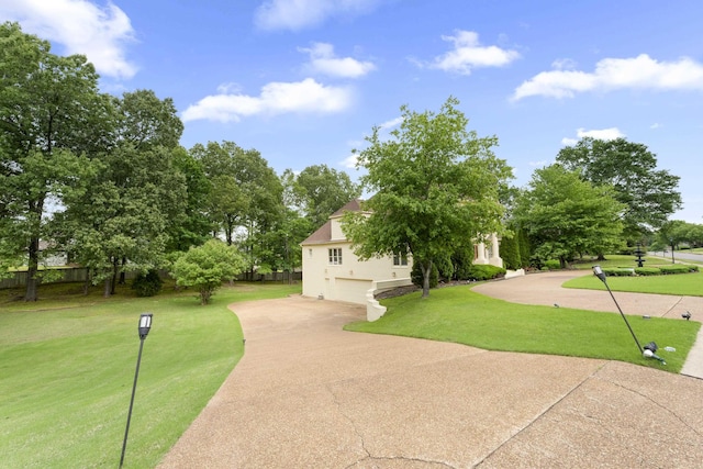 view of home's community featuring driveway, a garage, and a lawn