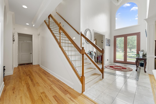 foyer featuring stairs, baseboards, a towering ceiling, recessed lighting, and ornamental molding
