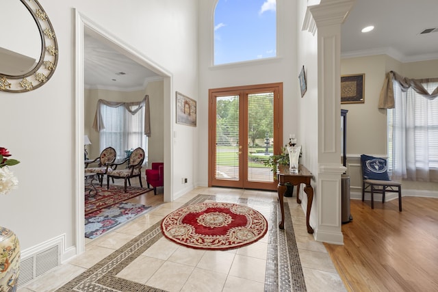 entrance foyer with ornate columns, baseboards, crown molding, inlaid floor details, and recessed lighting