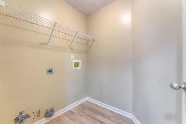 laundry area featuring hookup for a washing machine, light wood finished floors, electric dryer hookup, and baseboards