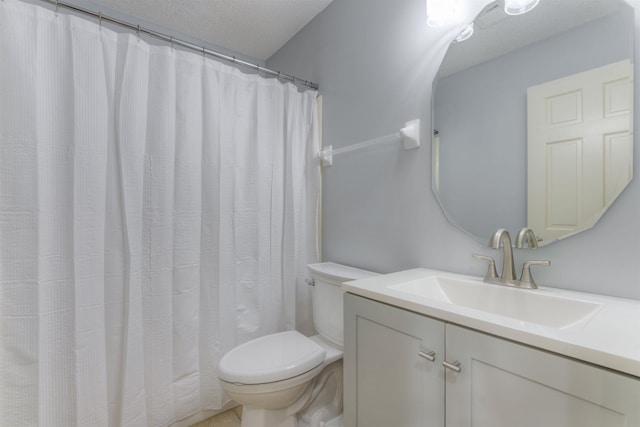 full bath with toilet, vanity, and a textured ceiling