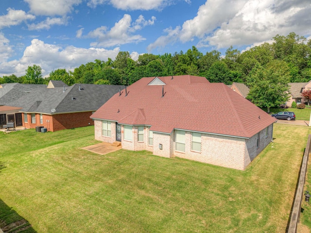 rear view of property with a yard, brick siding, and a patio