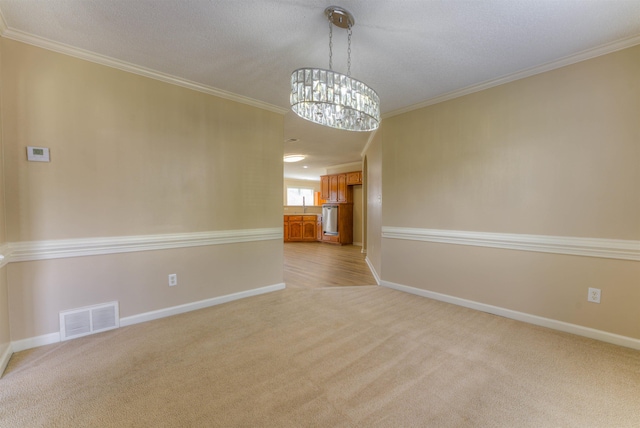 carpeted spare room featuring a chandelier, crown molding, and baseboards