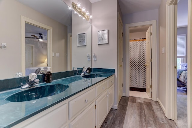 1917 Steeplebrook Cv, Cordova, TN 38016 - ensuite bathroom featuring wood finished floors, double vanity, baseboards, and curtained shower
