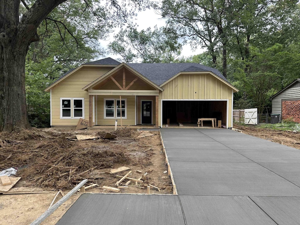 6227 Quince Rd, Memphis, TN 38119 - view of front facade with asphalt driveway, an attached garage, a porch, and board and batten siding