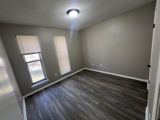 2151 Ptarmigan Trl, Memphis, TN 38134 - spare room with dark wood-style floors, a textured ceiling, and baseboards