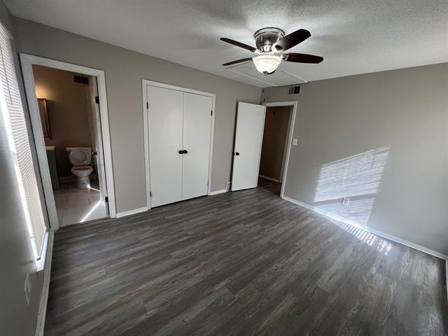 2151 Ptarmigan Trl, Memphis, TN 38134 - unfurnished bedroom with dark wood-style floors, baseboards, a closet, a ceiling fan, and ensuite bath