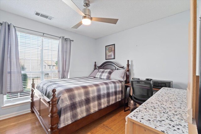 2518 Bassfield Dr, Memphis, TN 38133 - bedroom featuring light wood-style flooring, a textured ceiling, baseboards, and ceiling fan
