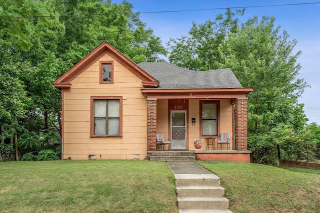 2102 Carr Ave, Memphis, TN 38104 - bungalow-style house featuring a porch, roof with shingles, a front yard, and brick siding