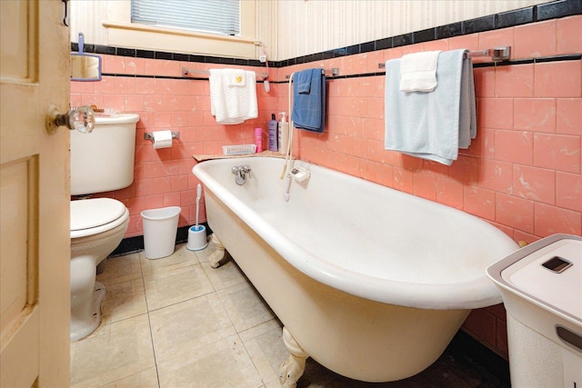 2102 Carr Ave, Memphis, TN 38104 - bathroom featuring tile walls, toilet, a bathtub, and wainscoting