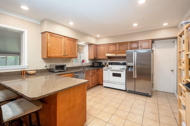 4152 Barfield Rd, Memphis, TN 38117 - kitchen featuring appliances with stainless steel finishes, under cabinet range hood, a peninsula, brown cabinetry, and recessed lighting