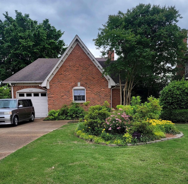 view of front of home with brick siding, a front yard, an attached garage, and a chimney