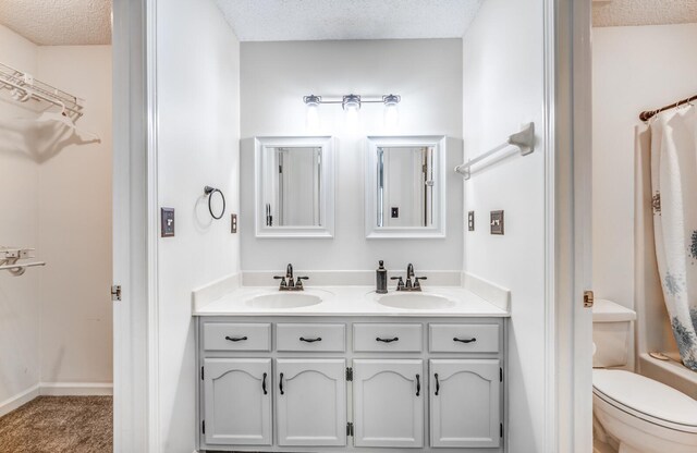 6686 Elmore Ridge Ln, Memphis, TN 38134 - bathroom featuring a textured ceiling, double vanity, and toilet