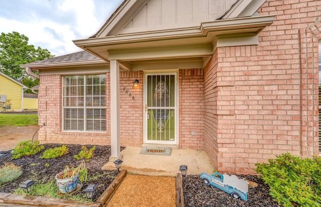 6686 Elmore Ridge Ln, Memphis, TN 38134 - doorway to property with brick siding, board and batten siding, and roof with shingles