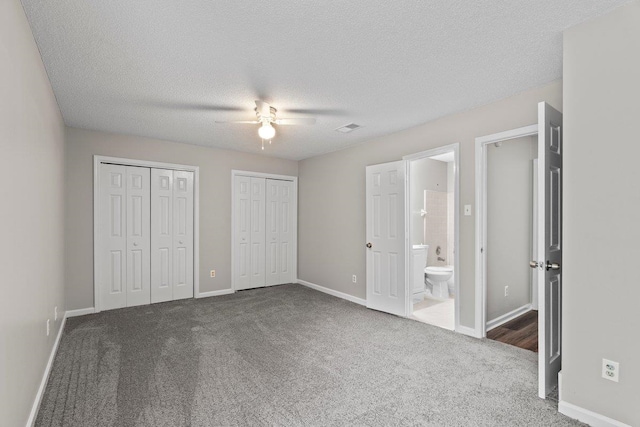 5544 Blossom Ln, Memphis, TN 38115 - unfurnished bedroom with carpet flooring, multiple closets, baseboards, connected bathroom, and a textured ceiling