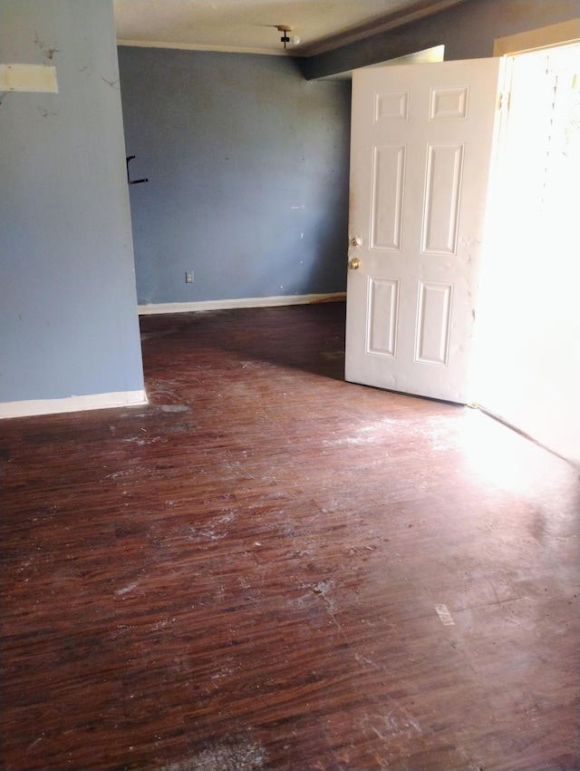 empty room featuring wood-type flooring and baseboards