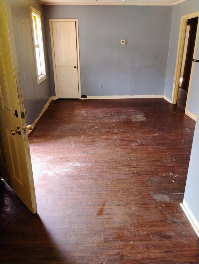 unfurnished room with wood finished floors and baseboards