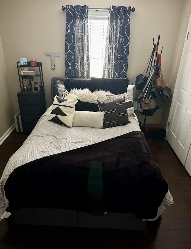 bedroom with baseboards and dark wood finished floors